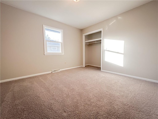 unfurnished bedroom featuring carpet flooring and a closet