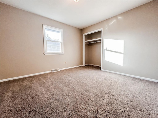 unfurnished bedroom with carpet flooring and a closet