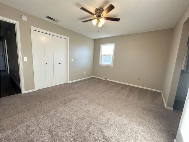 unfurnished bedroom featuring ceiling fan, carpet floors, and a closet