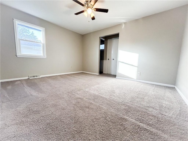 carpeted spare room with ceiling fan