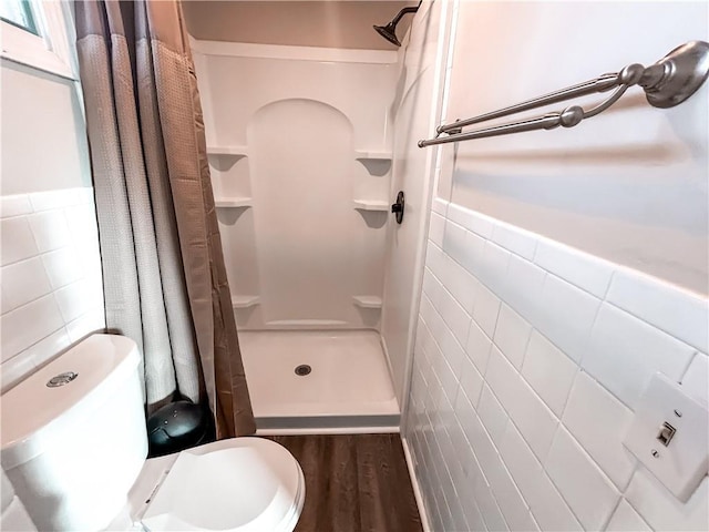 bathroom featuring hardwood / wood-style floors, toilet, tile walls, and a shower with shower curtain