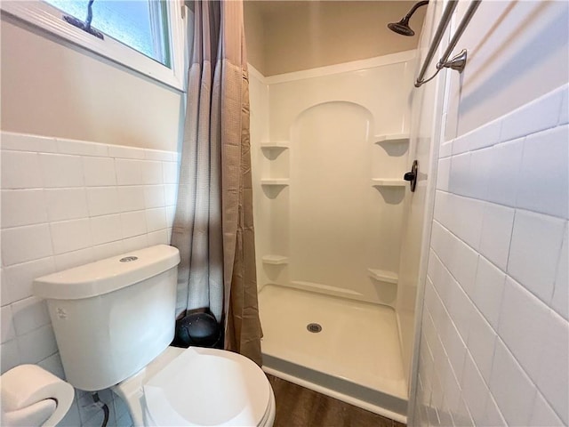 bathroom featuring hardwood / wood-style flooring, toilet, walk in shower, and tile walls