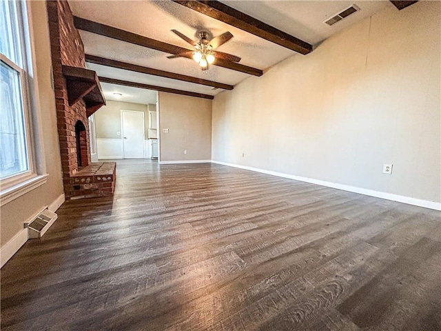 empty room featuring beam ceiling, dark hardwood / wood-style floors, and ceiling fan