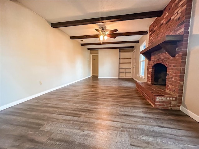 unfurnished living room featuring beam ceiling, ceiling fan, dark hardwood / wood-style floors, and a brick fireplace