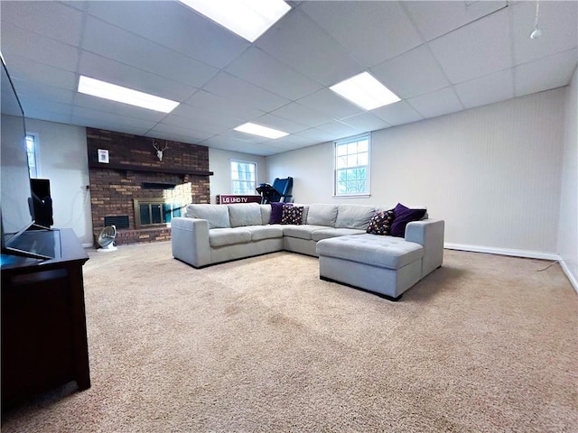 living room featuring carpet, a drop ceiling, and a fireplace