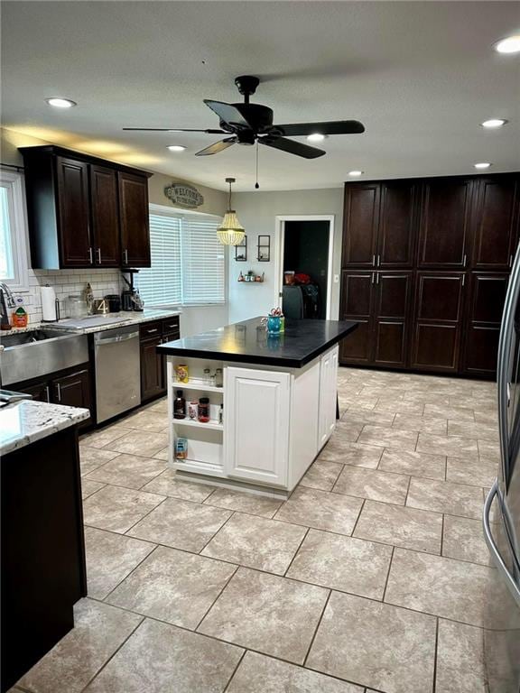 kitchen featuring sink, dishwasher, a kitchen island, backsplash, and white cabinets