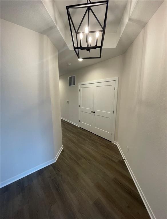 hall with an inviting chandelier and dark hardwood / wood-style floors