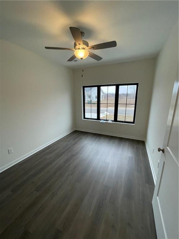 spare room with ceiling fan and dark hardwood / wood-style flooring