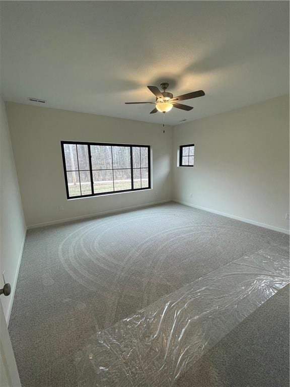 empty room with ceiling fan and carpet