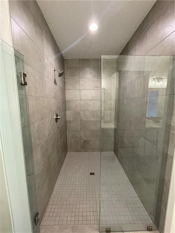 bathroom featuring an enclosed shower and a textured ceiling