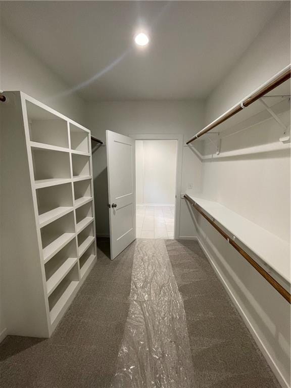 spacious closet featuring dark colored carpet