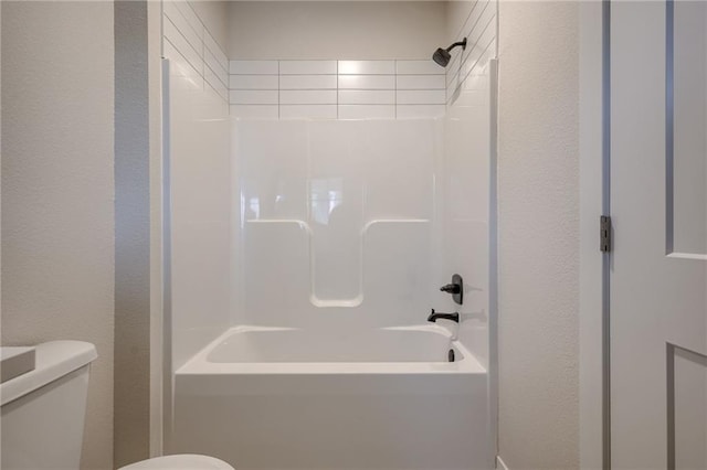 full bathroom with a textured wall and toilet