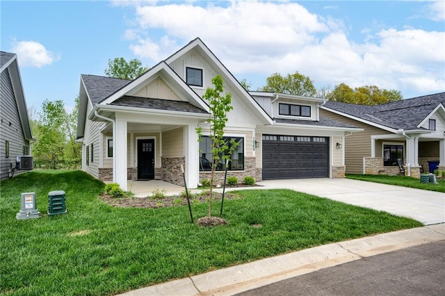 craftsman house with a front lawn, stone siding, board and batten siding, central air condition unit, and driveway