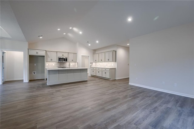 unfurnished living room featuring a sink, high vaulted ceiling, recessed lighting, baseboards, and dark wood-style floors