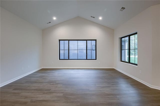 spare room with lofted ceiling, dark wood finished floors, and visible vents