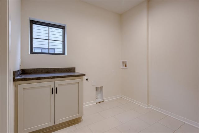 laundry area featuring baseboards, hookup for a washing machine, cabinet space, light tile patterned floors, and hookup for an electric dryer