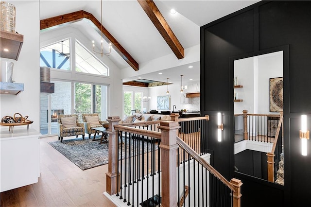 interior space featuring a wealth of natural light, vaulted ceiling with beams, a fireplace, and wood-type flooring