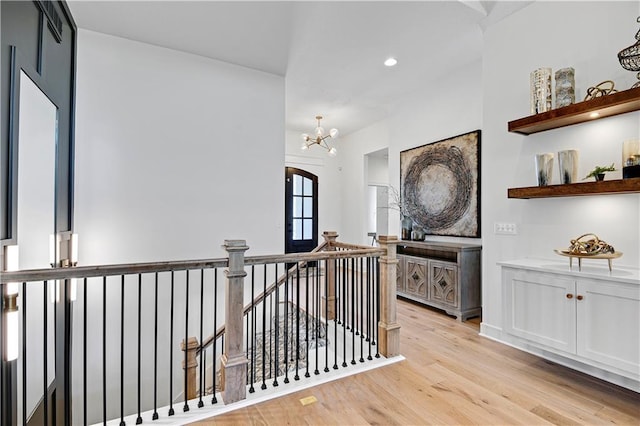 hall featuring light hardwood / wood-style flooring and an inviting chandelier