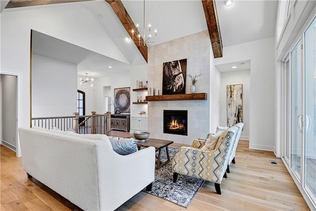 living room featuring light hardwood / wood-style floors, beam ceiling, and high vaulted ceiling