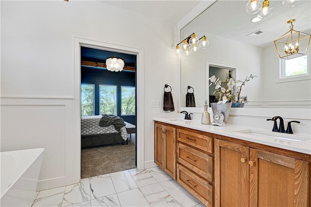 bathroom featuring vanity, a tub, and a chandelier