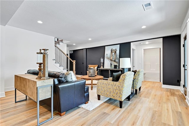 living room with a textured ceiling and light hardwood / wood-style flooring