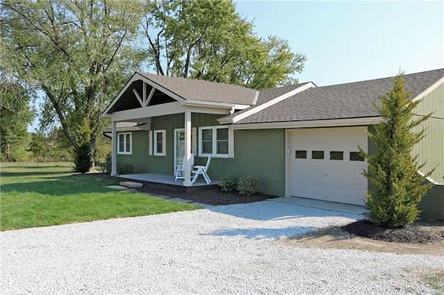 view of front of house featuring a front yard, a garage, and a porch