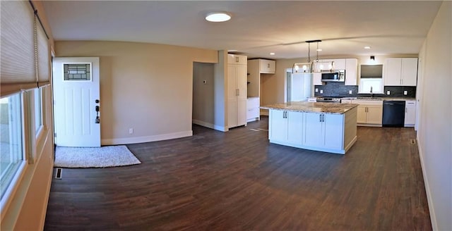 kitchen with white cabinets, hanging light fixtures, dark hardwood / wood-style flooring, appliances with stainless steel finishes, and a kitchen island