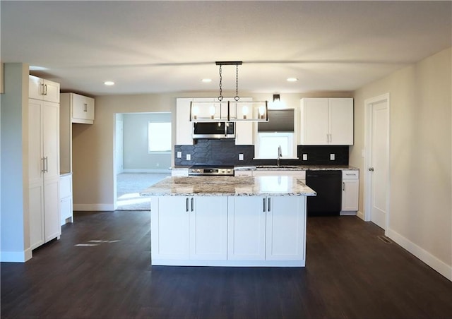 kitchen with white cabinetry, stainless steel appliances, a center island, and pendant lighting