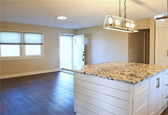 kitchen featuring white cabinetry, light stone countertops, decorative light fixtures, and dark hardwood / wood-style floors