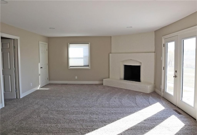 unfurnished living room with a healthy amount of sunlight, carpet flooring, and a fireplace