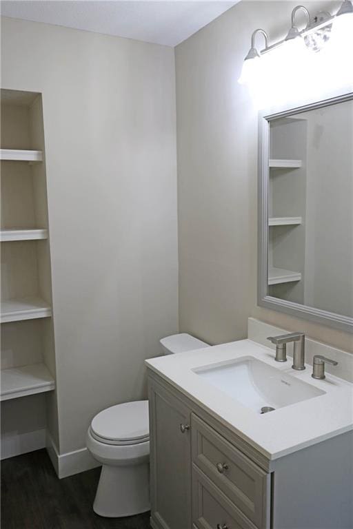 bathroom with vanity, hardwood / wood-style flooring, and toilet