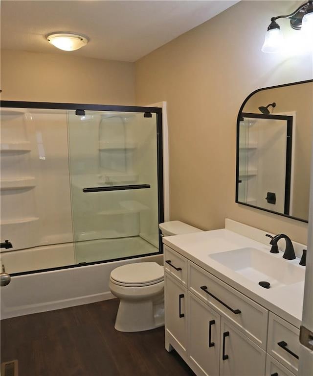 full bathroom featuring toilet, hardwood / wood-style floors, vanity, and enclosed tub / shower combo