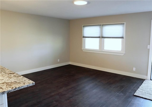 unfurnished room featuring dark wood-type flooring