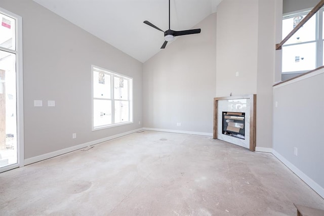 unfurnished living room with ceiling fan, a healthy amount of sunlight, a fireplace, and vaulted ceiling