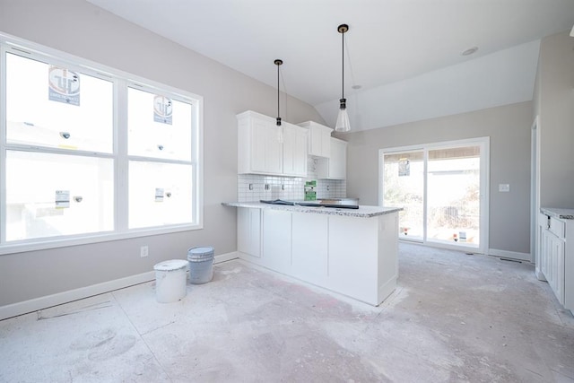 kitchen with decorative backsplash, kitchen peninsula, decorative light fixtures, white cabinets, and lofted ceiling