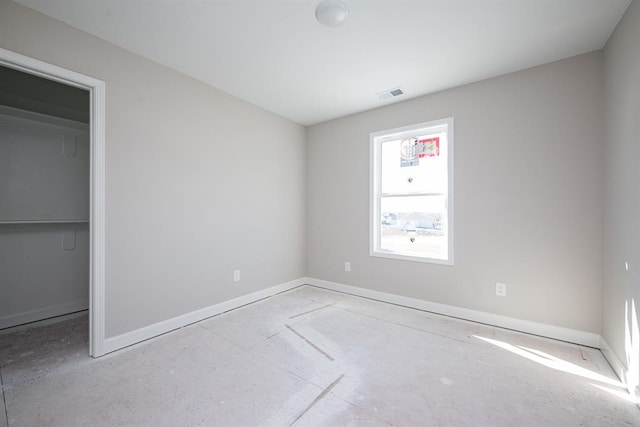 unfurnished bedroom featuring a walk in closet