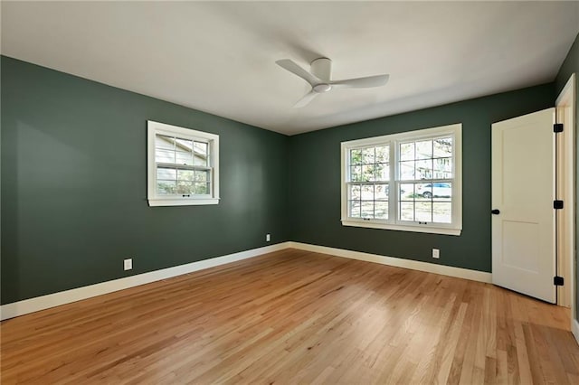 spare room featuring ceiling fan, light wood-type flooring, and a wealth of natural light