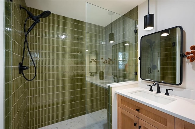 bathroom featuring tiled shower and vanity