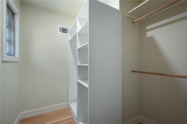 walk in closet with hardwood / wood-style floors