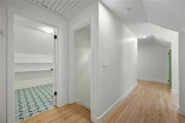 hall featuring light hardwood / wood-style flooring and lofted ceiling