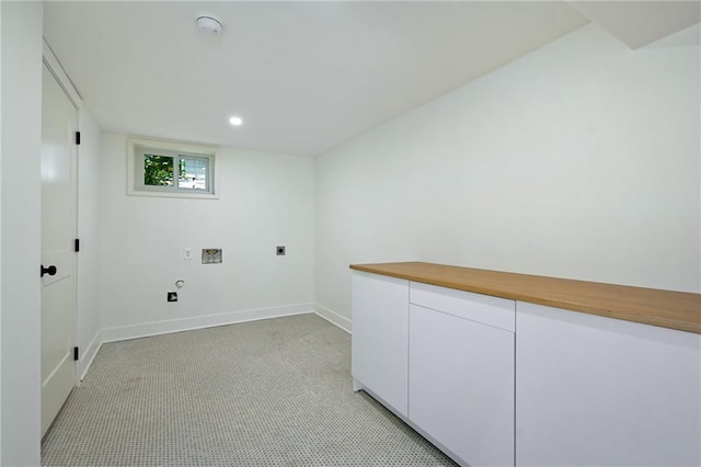 laundry room featuring hookup for an electric dryer, hookup for a washing machine, light colored carpet, and cabinets