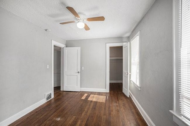 unfurnished bedroom with dark hardwood / wood-style flooring, a textured ceiling, a closet, and ceiling fan