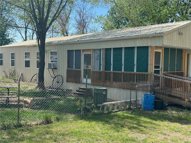 rear view of house with a sunroom and a lawn