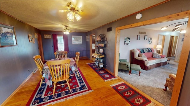 dining room with ceiling fan, crown molding, a textured ceiling, and hardwood / wood-style floors