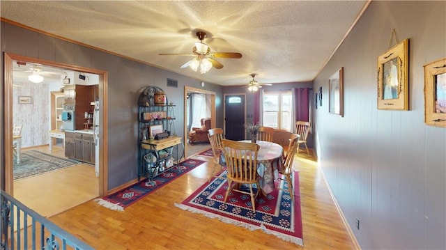 dining area featuring ceiling fan, a textured ceiling, and light hardwood / wood-style flooring