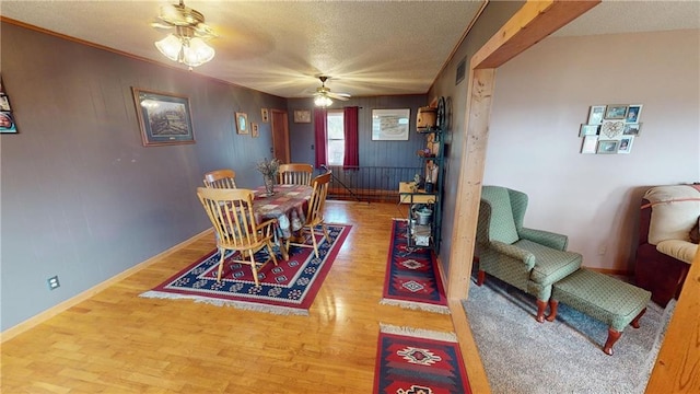 dining room featuring a textured ceiling, wood-type flooring, and ceiling fan