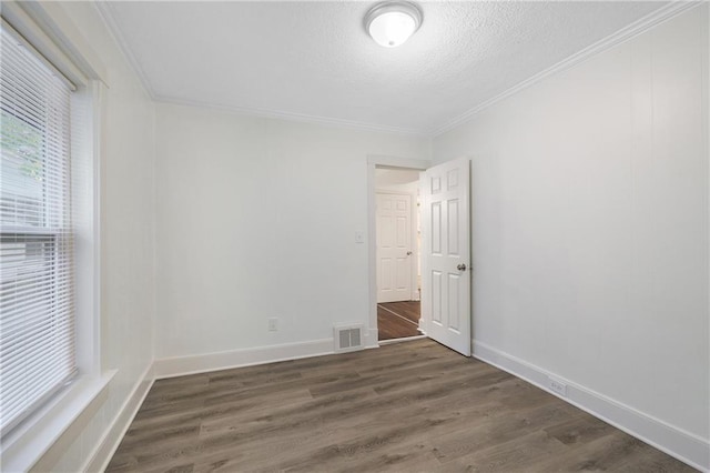 unfurnished room with crown molding, dark hardwood / wood-style floors, and a textured ceiling