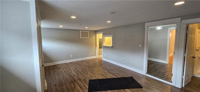 unfurnished room with dark wood-type flooring