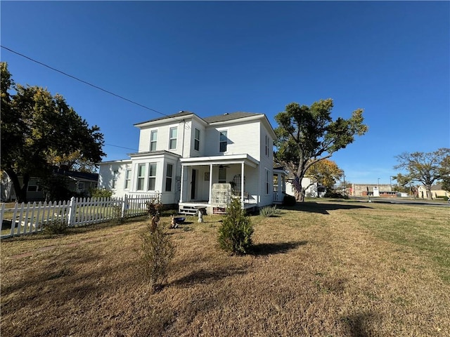 rear view of house with a yard and covered porch