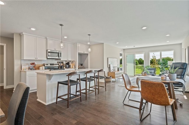 8701 SW Edgewater Dr, Blue Springs, MO 64064 - kitchen with appliances with stainless steel finishes, an island with sink, open floor plan, backsplash, and light countertops